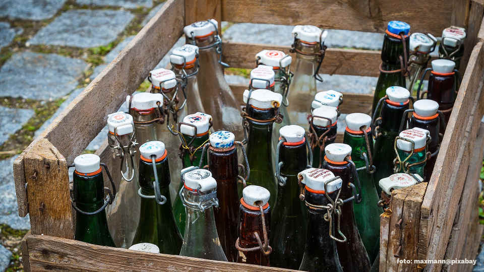 Mehrwegflaschen mit Bügelverschluss in einer Holzkiste.