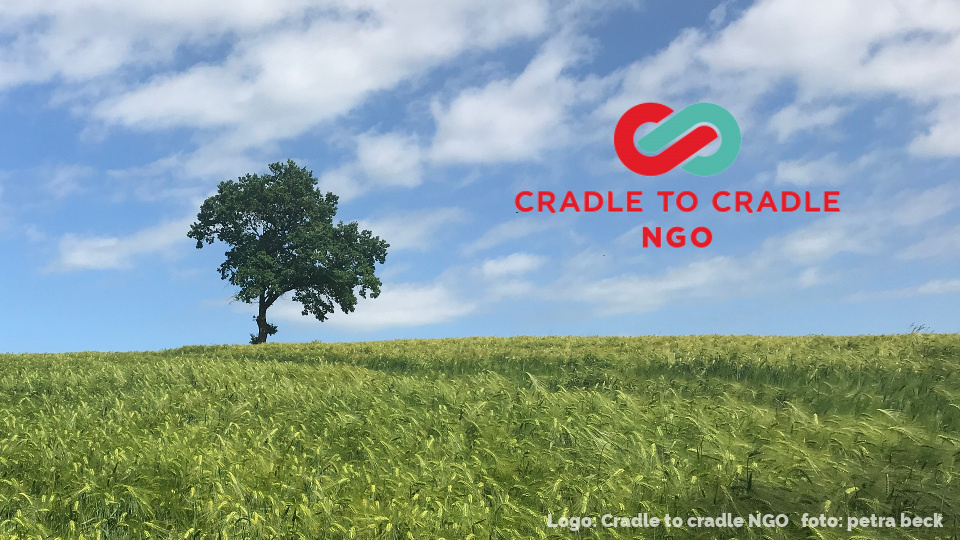 Ein einzelner Baum auf einem Feld und das Logo von Cradle to cradle