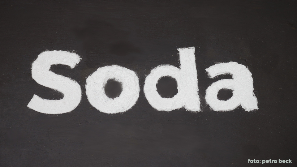 Das Wort Soda mit Pulver auf einer Schiefertafel.