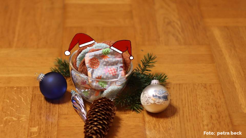 Schale mit plastikfreien selbstgenähten abschminkpads und Weihnachtsdekoration auf Holzfußboden.