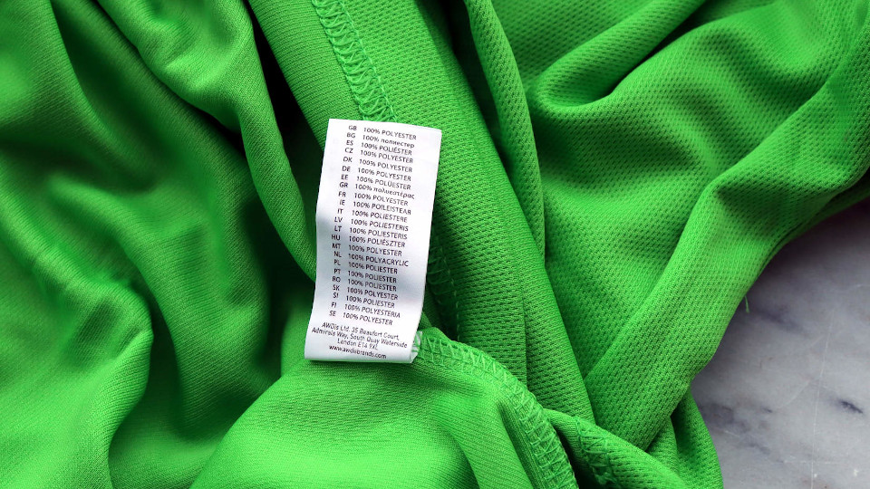 Das Etikett eines Sport-T-Shirtes. Es besteht aus 100% Polyester - was eigentlich Plastik bedeutet.